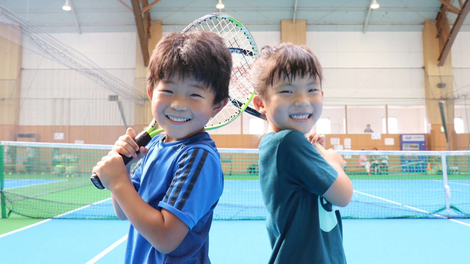 テニスラケットを持つ笑顔の子ども